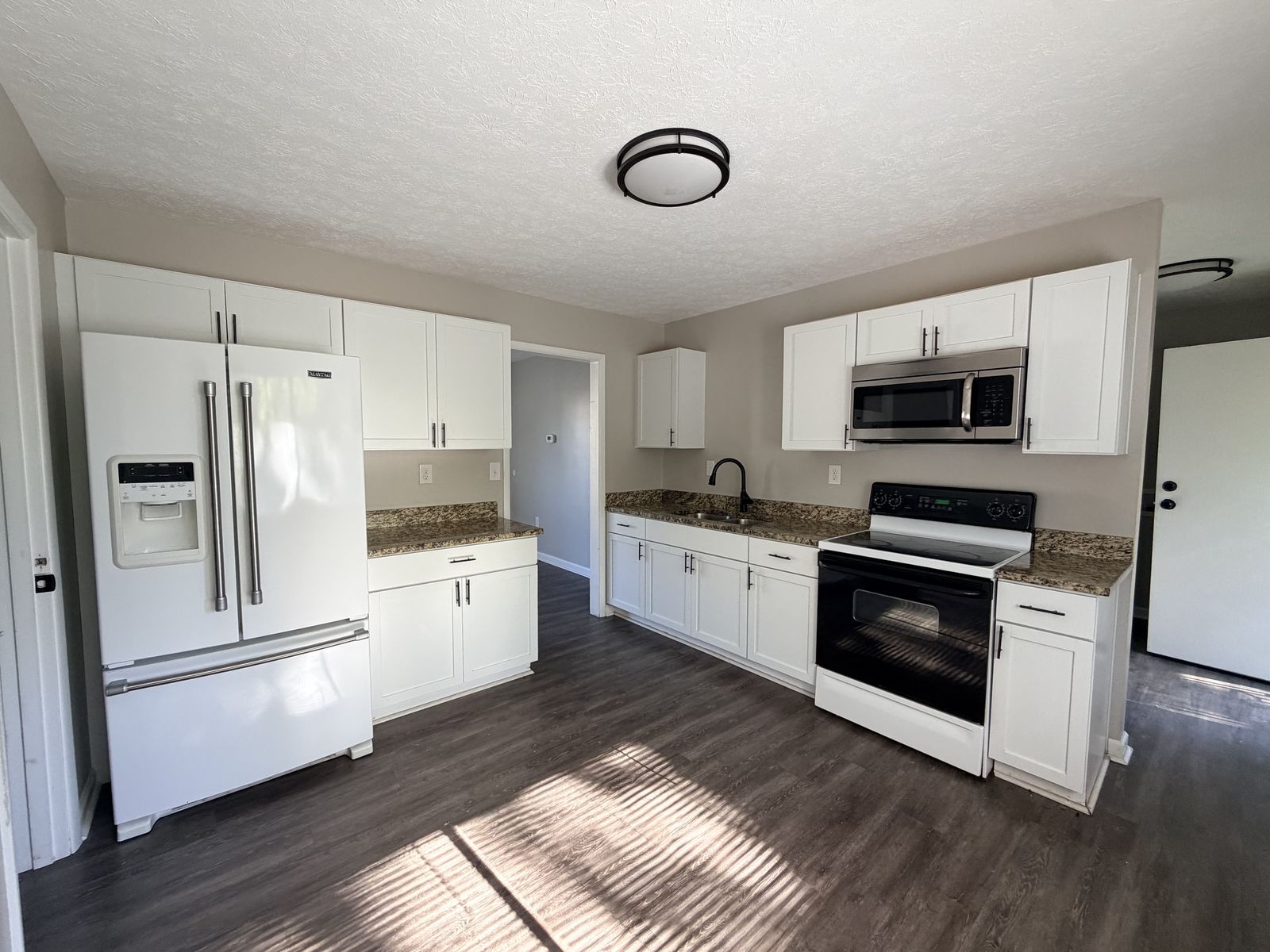 Kitchen with white cabinets and granite counters